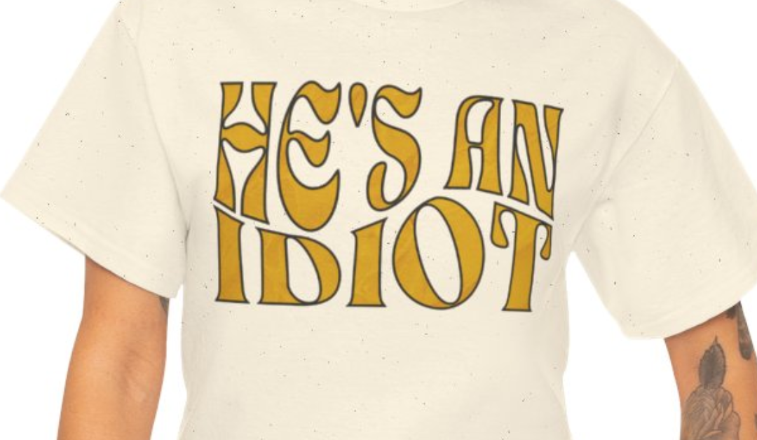 He’s An Idiot T-Shirt – Gold Wave Text Design